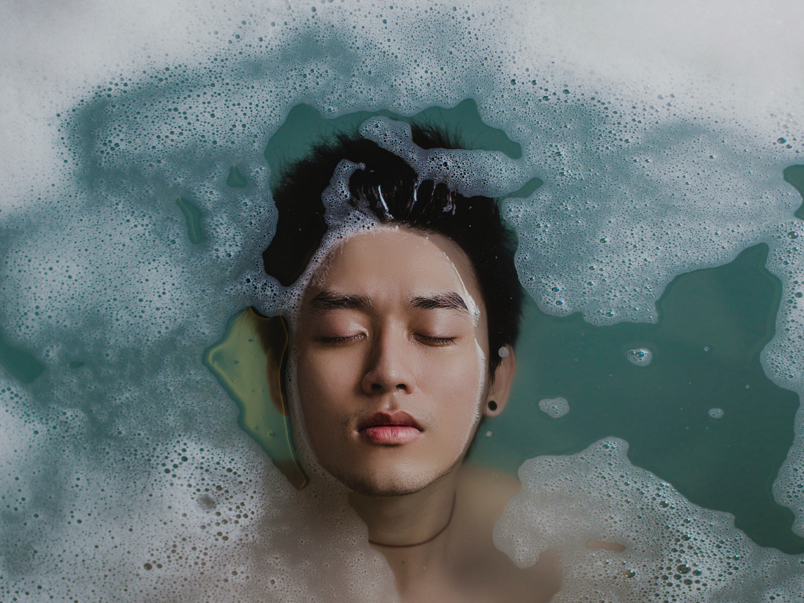 Man with head under water with bubbles